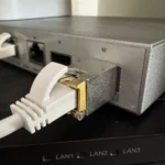 Bộ thu phát SFP+ 10GBase-T đang cắm vào cổng mạng trên switch, thể hiện sự nhỏ gọn nhưng tiềm ẩn vấn đề nhiệt độ.