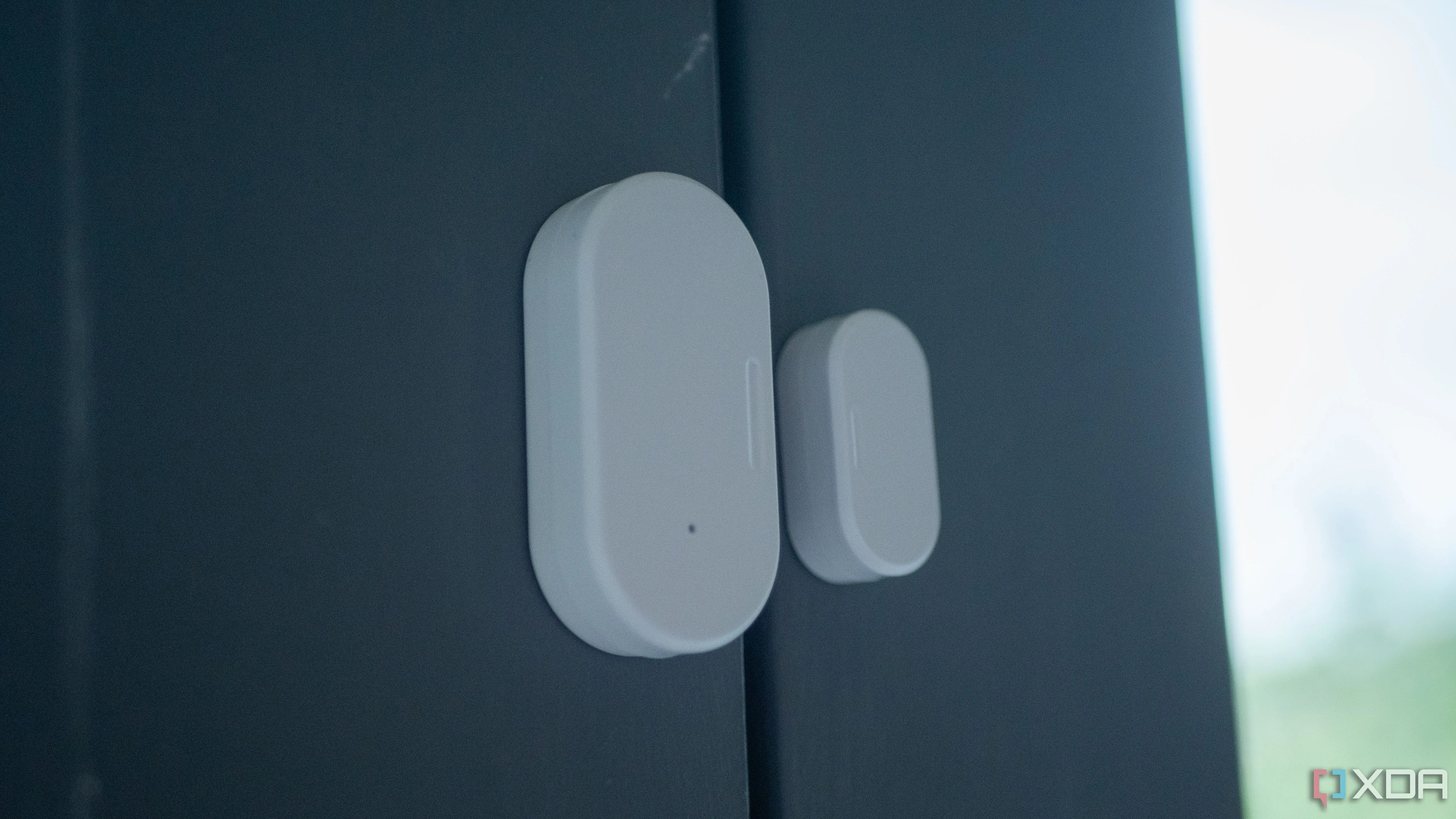 Cảm biến cửa Zigbee của Aqara gắn trên cửa ban công màu trắng