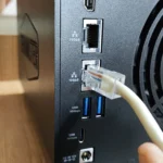 Cắm cáp Ethernet vào cổng LAN 10GbE của thiết bị NAS TerraMaster F4-424 Max, minh họa khả năng nâng cấp băng thông của cáp quang