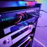 Cận cảnh tủ rack mạng gia đình với nhiều thiết bị switch và thiết bị nghe nhìn (AVR), minh họa hệ thống mạng prosumer đã được nâng cấp lên 10GbE.