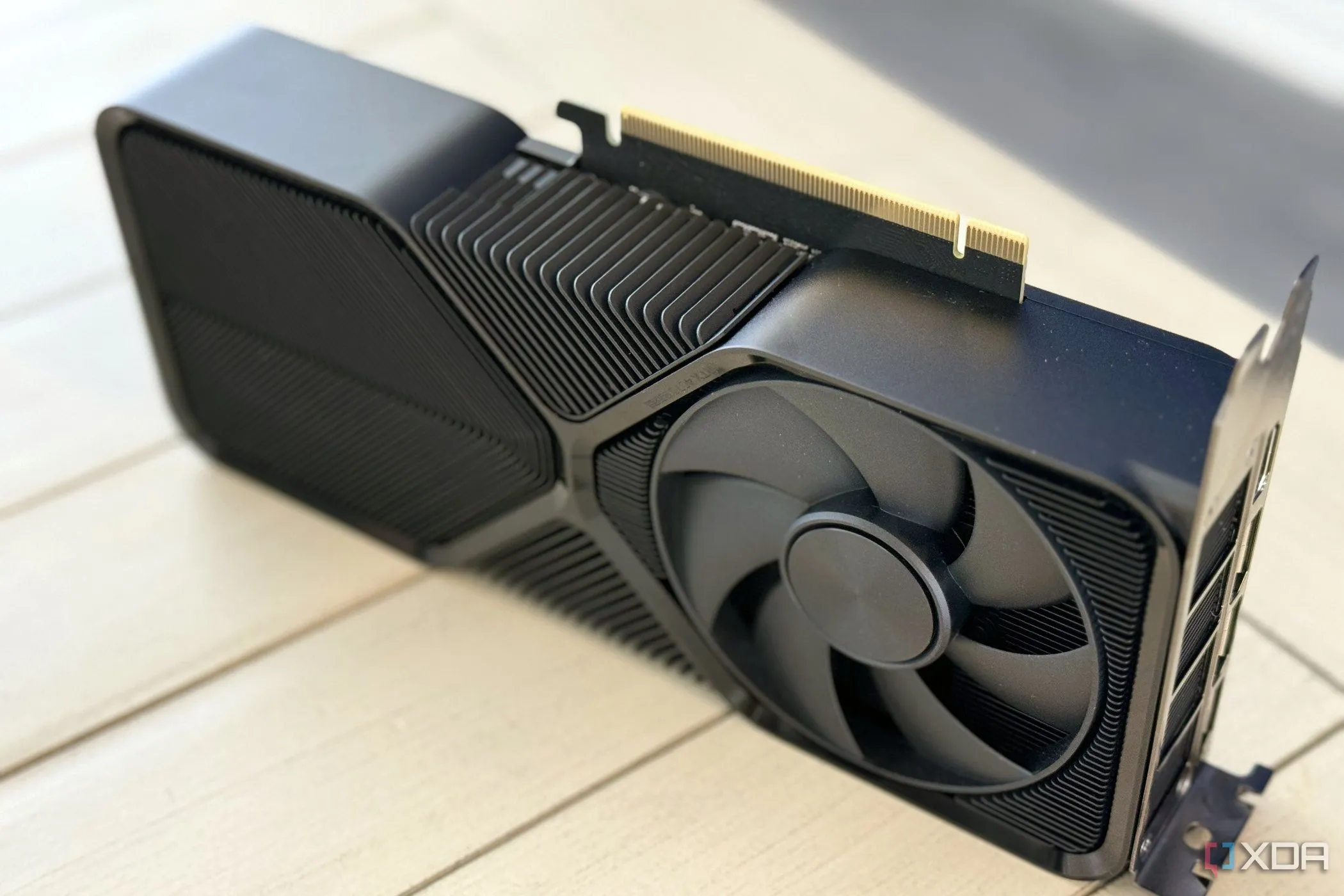 Card đồ họa NVIDIA GeForce RTX 4070 SUPER Founders Edition dựng đứng trên bàn, hiển thị khe PCIe