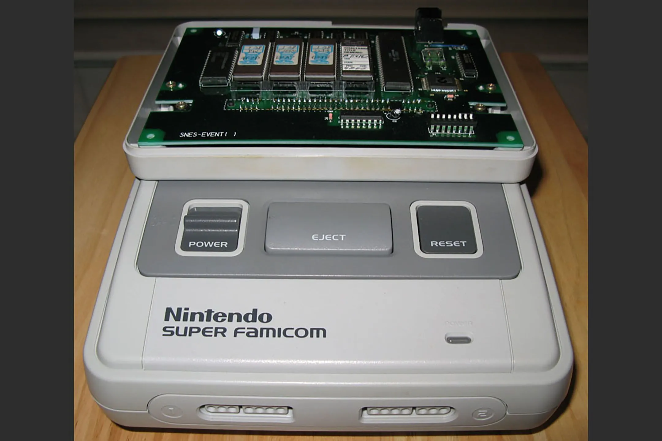 Cartridge Nintendo Campus Challenge 1992 cho SNES với nắp đậy phía trên được tháo rời, để lộ bo mạch phức tạp, nhiều chip ROM và các cổng kết nối ngoại vi.
