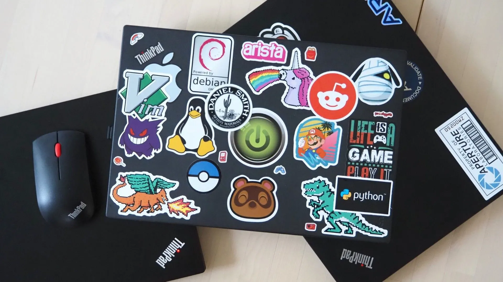Chiếc laptop ThinkPad X270 dán đầy sticker của Jessica Nicholson, đặt trên bộ sưu tập ThinkPad của cô, thể hiện sự cá nhân hóa và niềm đam mê.