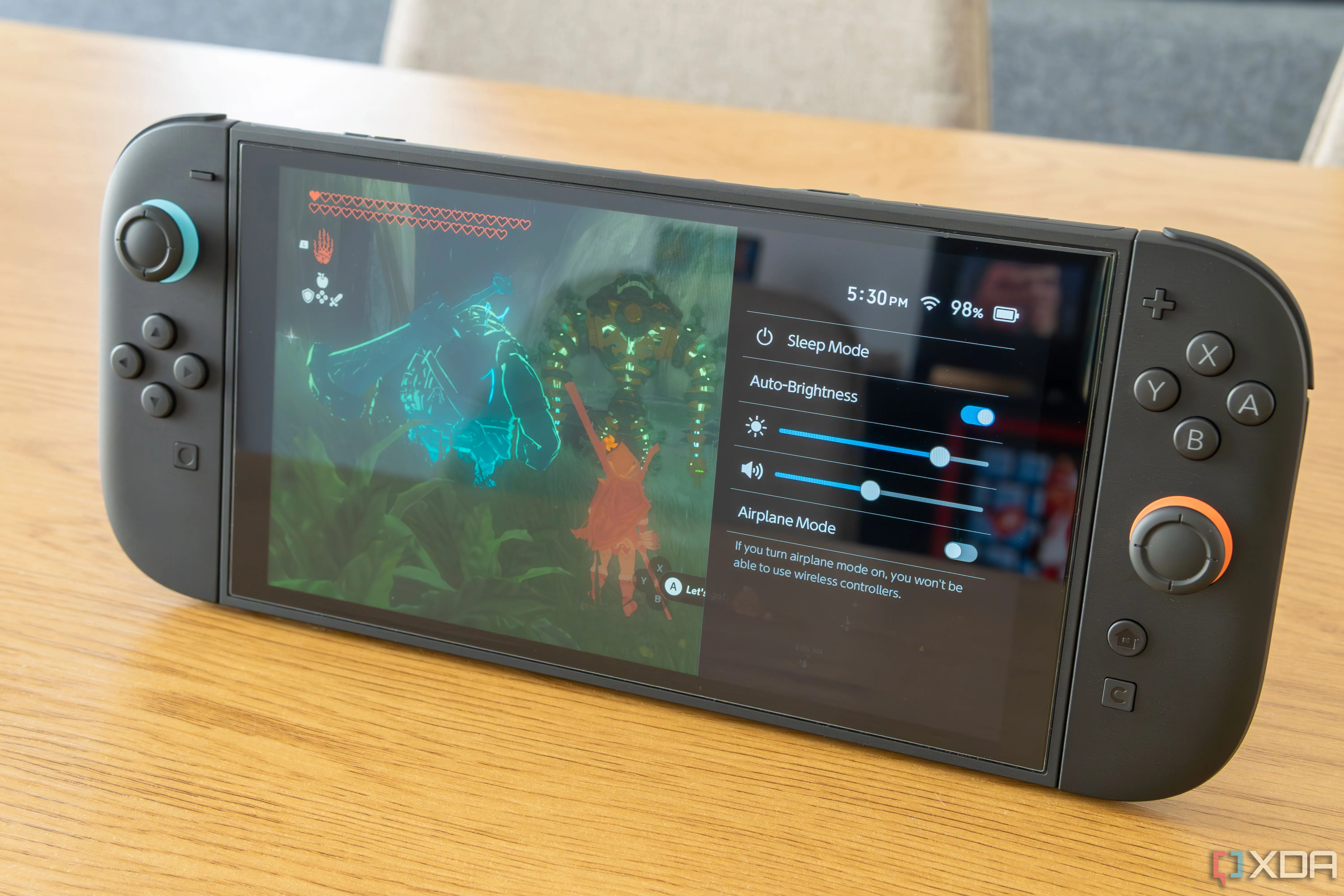 Console Nintendo Switch 2 đang đứng và hiển thị lớp phủ pin trên The Legend of Zelda Tears of the Kingdom
