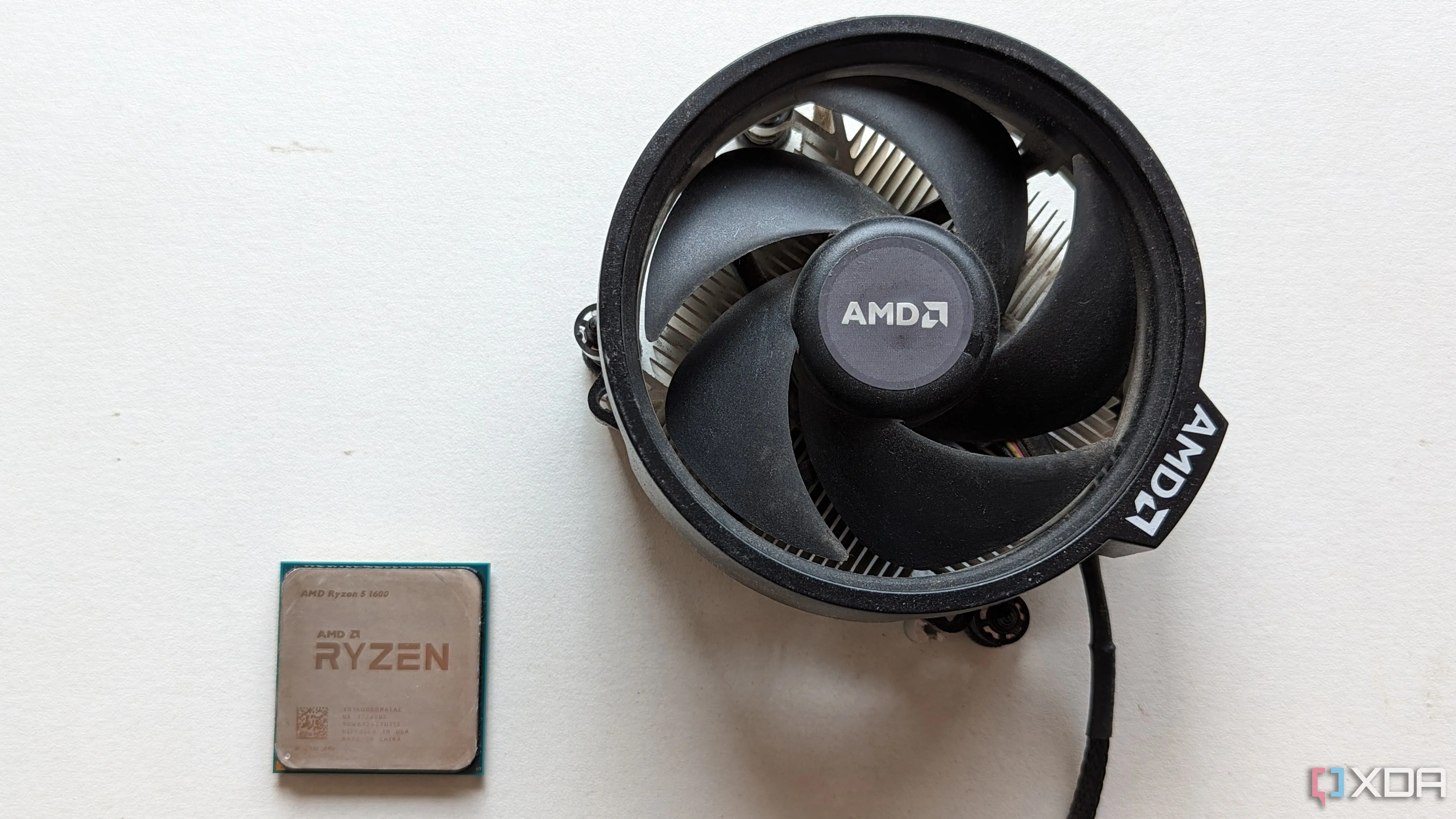CPU AMD Ryzen 5 1600 và tản nhiệt đi kèm trên nền trắng, đại diện cho các chip 4 nhân hiện đại có kiến trúc tiên tiến