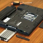 Hình ảnh một chiếc laptop Lenovo x220 được mở nắp, cho thấy các khe cắm mở rộng và vị trí pin đã được tháo ra, minh họa việc nâng cấp pin laptop