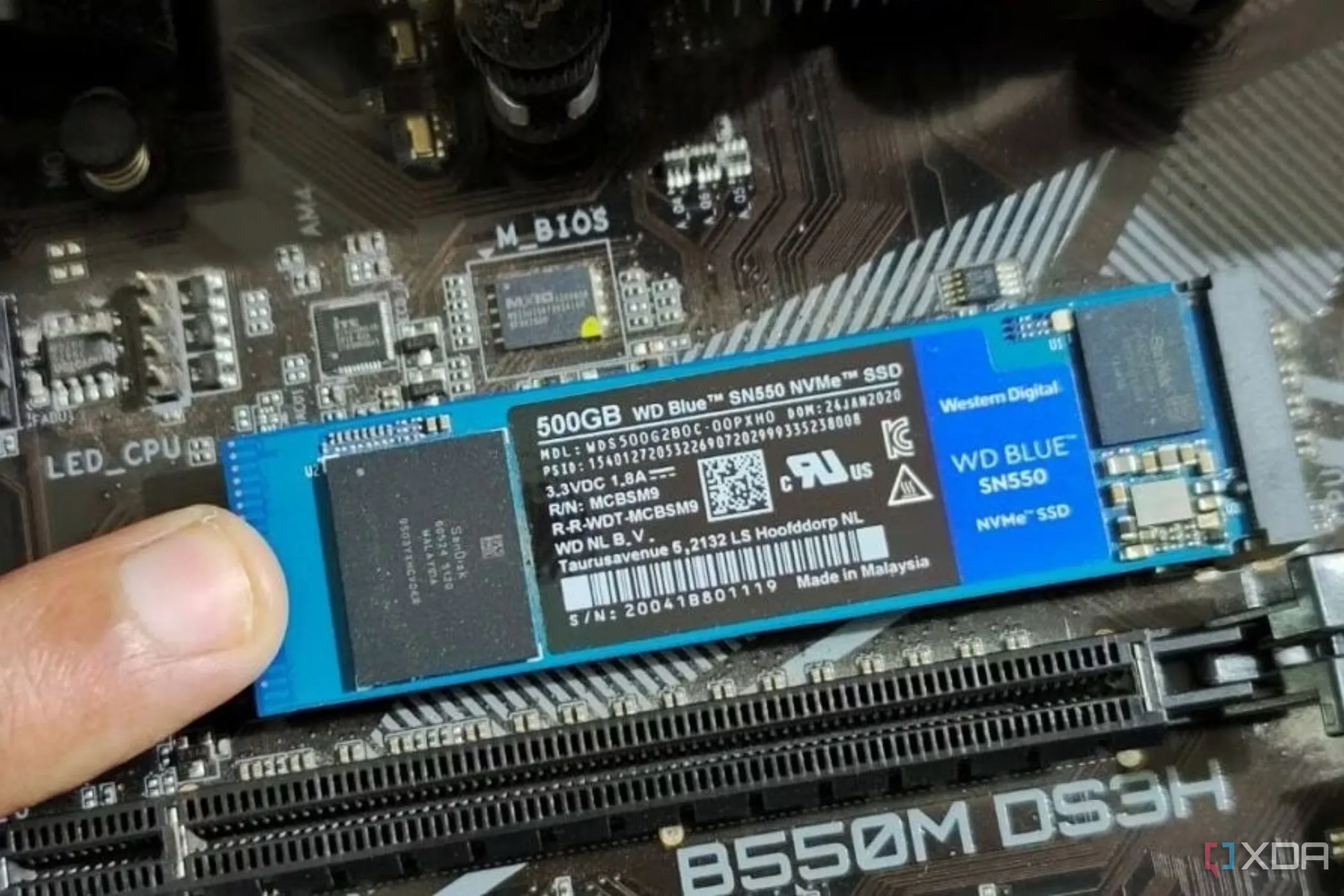 Hình ảnh một người đang giữ một mô-đun SSD M.2 bằng ngón tay.