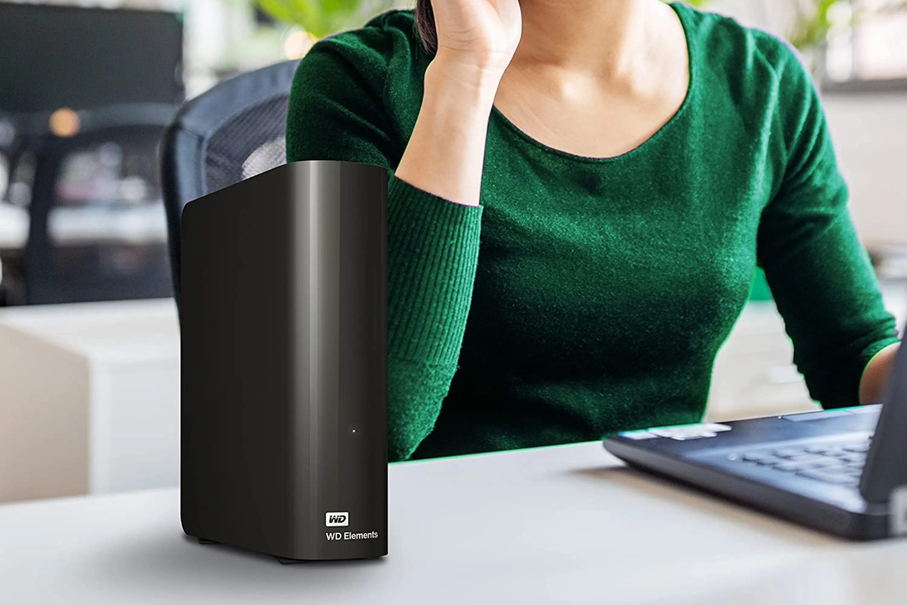 Hình ảnh ổ cứng Western Digital Elements 14TB đang được sử dụng cùng máy tính xách tay.