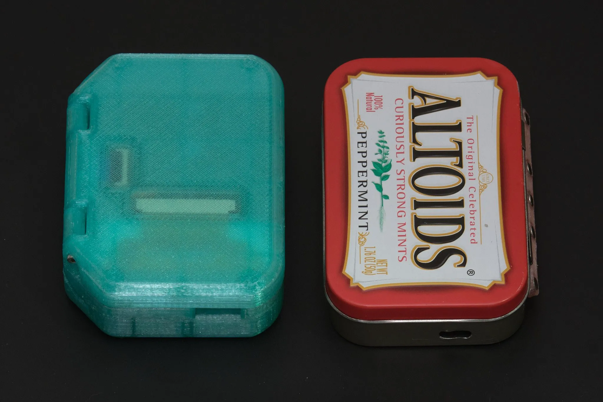 Kích thước Pi Tin so với hộp Altoids và các vật dụng khác, minh họa sự nhỏ gọn của máy chơi game cầm tay Raspberry Pi