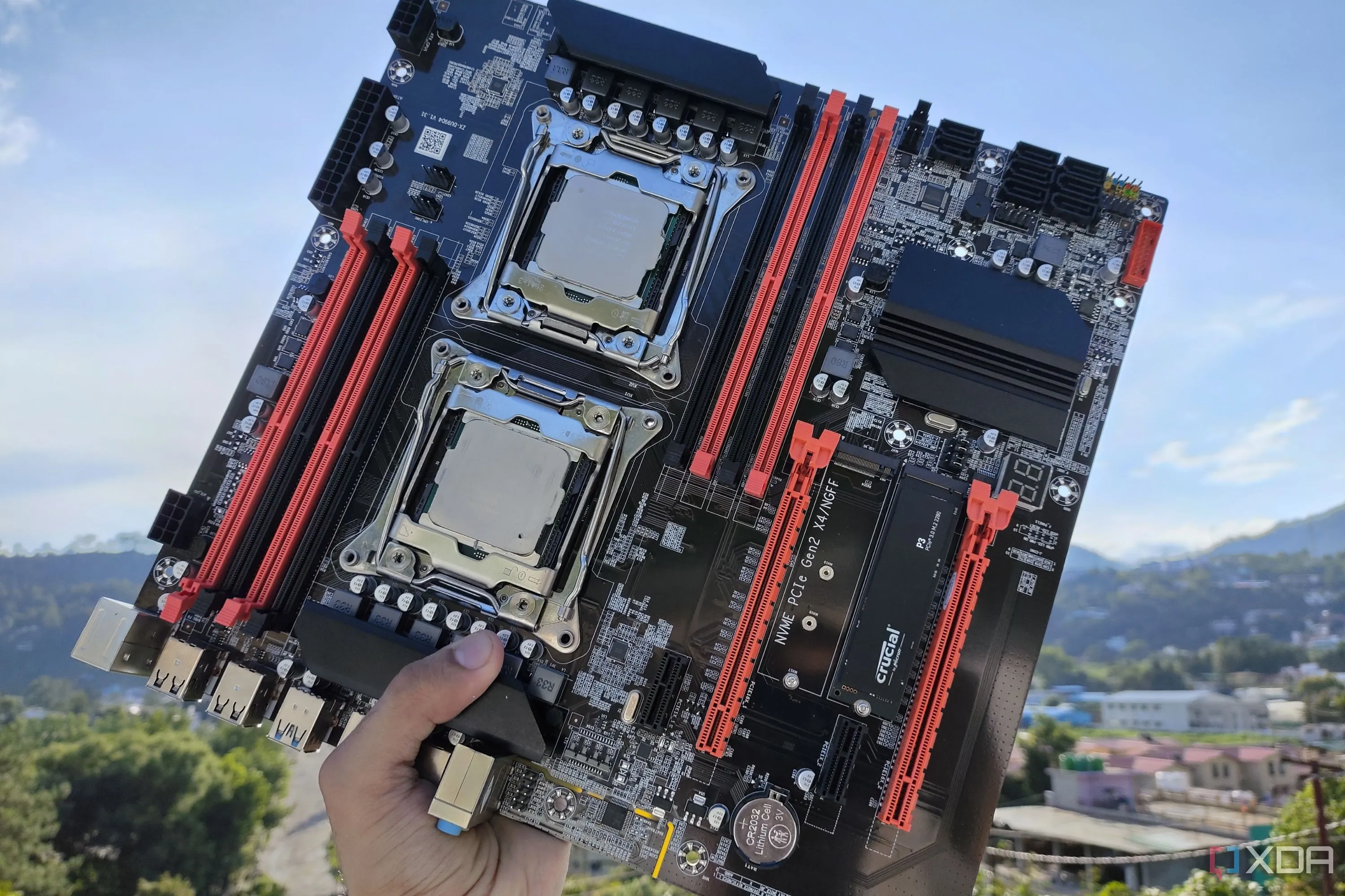 Một người đang cầm bo mạch chủ server X99 với hai CPU Intel Xeon đã lắp, cho thấy tổng quan linh kiện.
