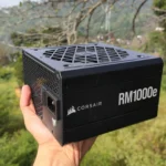 Người dùng cầm bộ nguồn Corsair RM1000e minh họa cho mức tiêu thụ điện năng cao của GPU