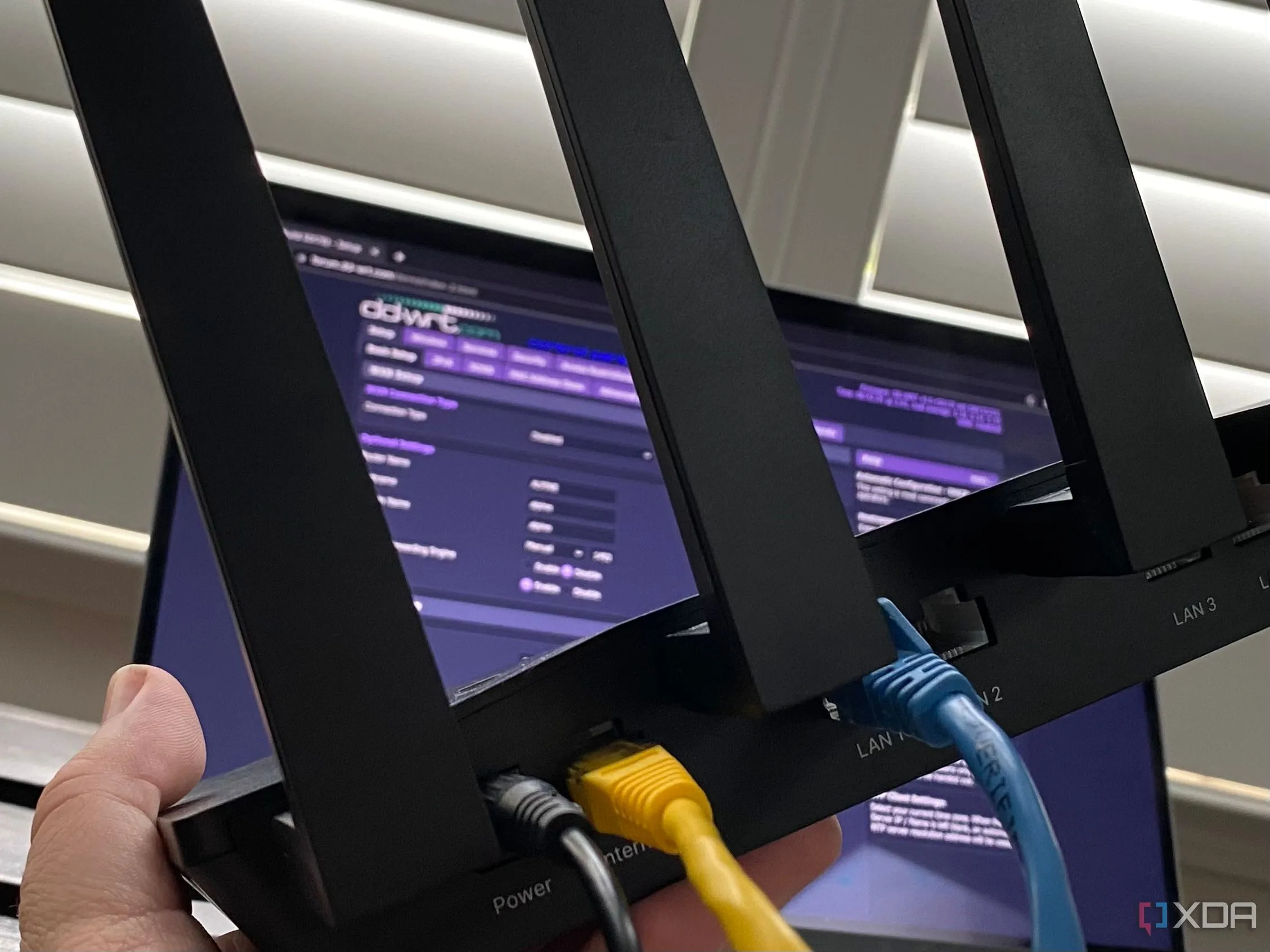Người dùng đang cài đặt và cấu hình router Wi-Fi với firmware DD-WRT thông qua máy tính xách tay, thể hiện việc tinh chỉnh mạng.