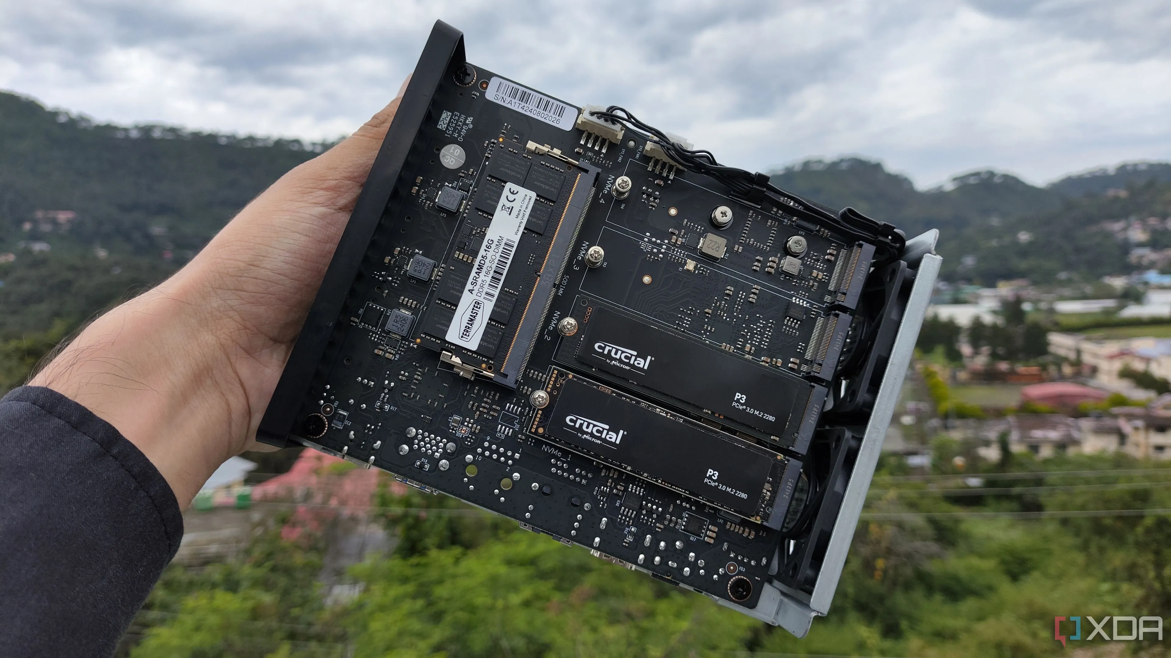 Người dùng đang cầm NAS TerraMaster F8 SSD Plus với hai ổ SSD PCIe 3 được lắp, nhấn mạnh tầm quan trọng của việc cập nhật firmware và ứng dụng để bảo vệ dữ liệu.