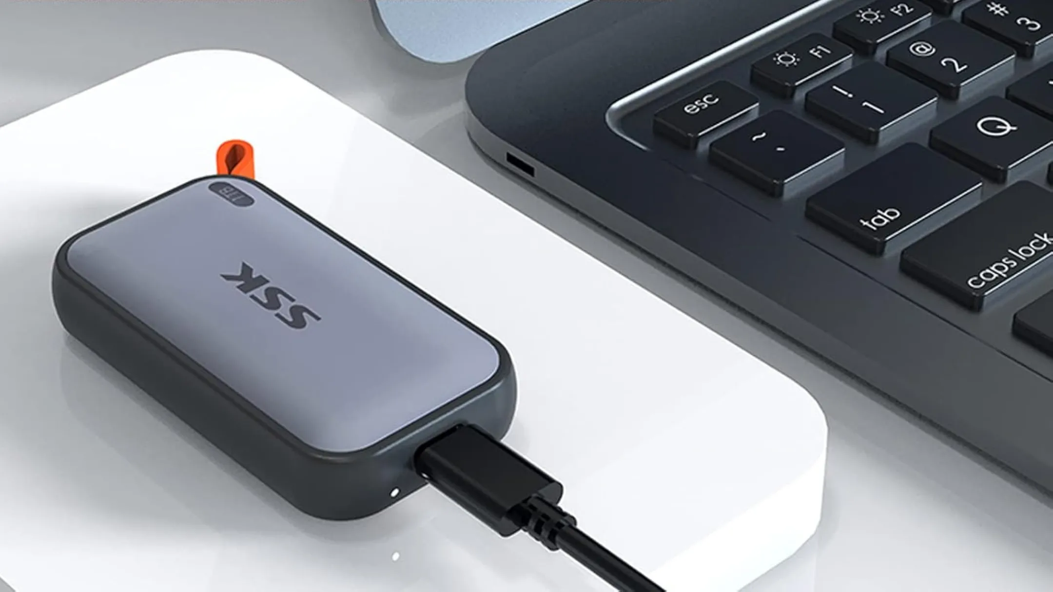 Ổ cứng SSD di động SSK 1TB đặt cạnh máy tính xách tay, thể hiện kích thước nhỏ gọn