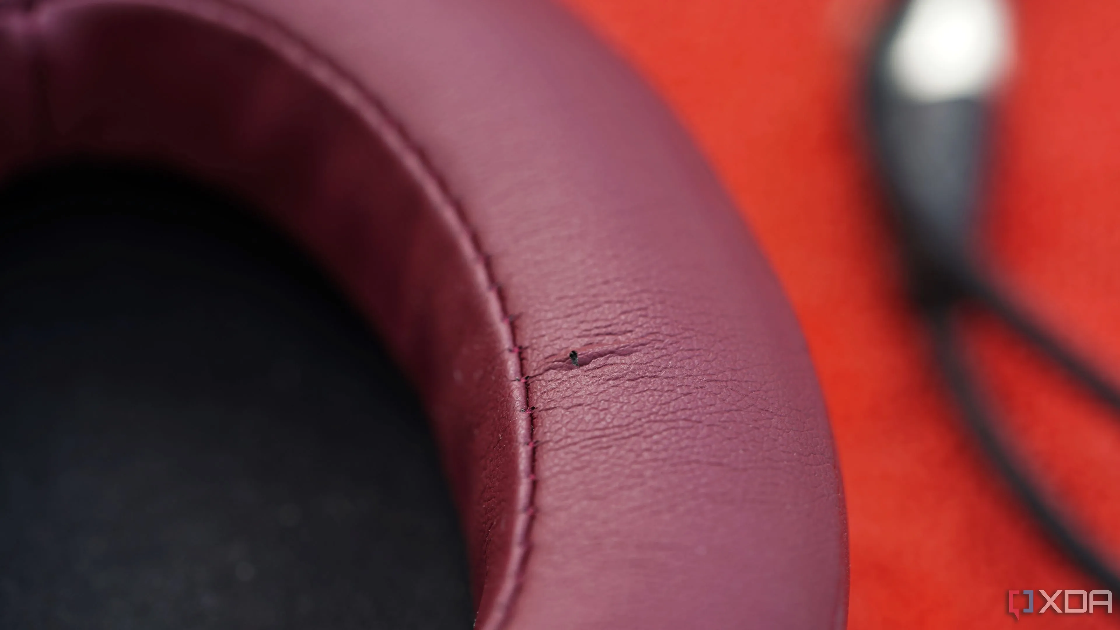 Vết rách nhỏ trên đệm tai nghe (earpad) màu hồng, minh chứng cho việc tháo lắp thường xuyên có thể gây hư hại.